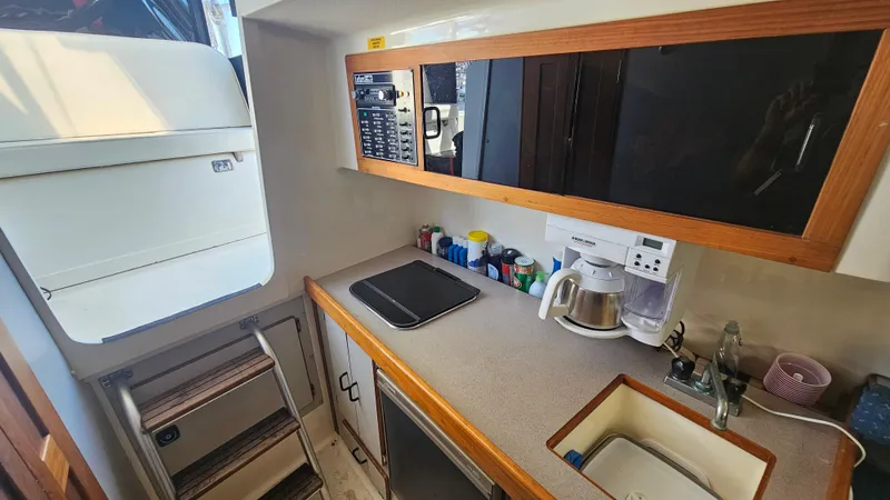 1992 Luhrs Tournament 300 galley with sink, stove, and storage cabinets.