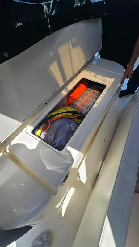 Open storage compartment on 1992 Luhrs Tournament 300 boat, containing safety gear and equipment.