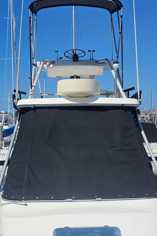 1992 Luhrs Tournament 300 boat with flybridge and black canvas cover.