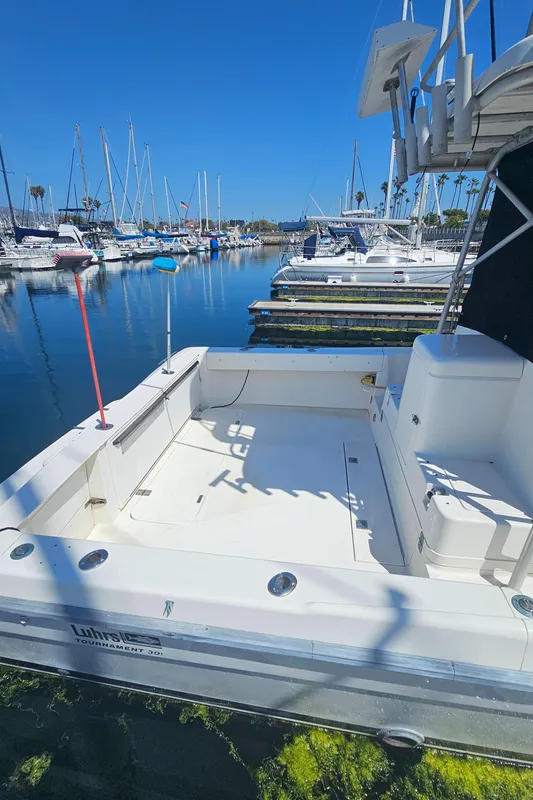 1992 Luhrs Tournament 300 boat docked in a marina under clear blue skies.