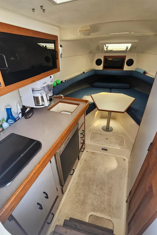 1992 Luhrs Tournament 300 cabin interior with kitchenette, seating area, and table.