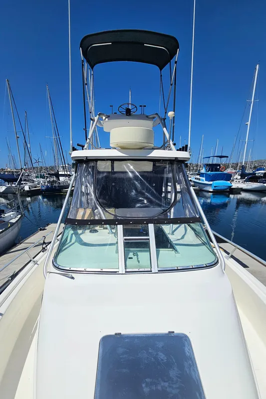 1992 Luhrs Tournament 300 boat docked in a marina under clear blue skies.