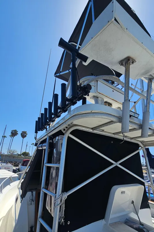 1992 Luhrs Tournament 300 boat with tower and rod holders under clear blue sky.