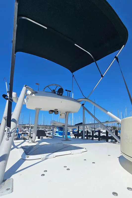 1992 Luhrs Tournament 300 boat helm with canopy, docked under clear blue sky.