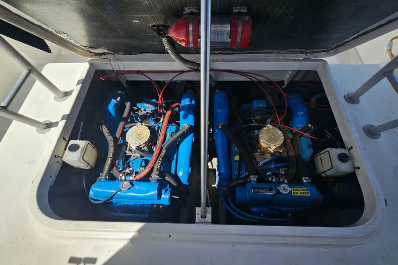 Engine compartment of 1992 Luhrs Tournament 300 with dual blue engines and fire extinguisher.