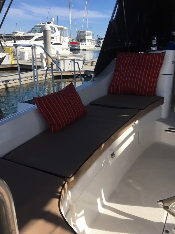 2006 Hunter 41 Deck Salon yacht interior with cushioned seating and striped pillows at marina.