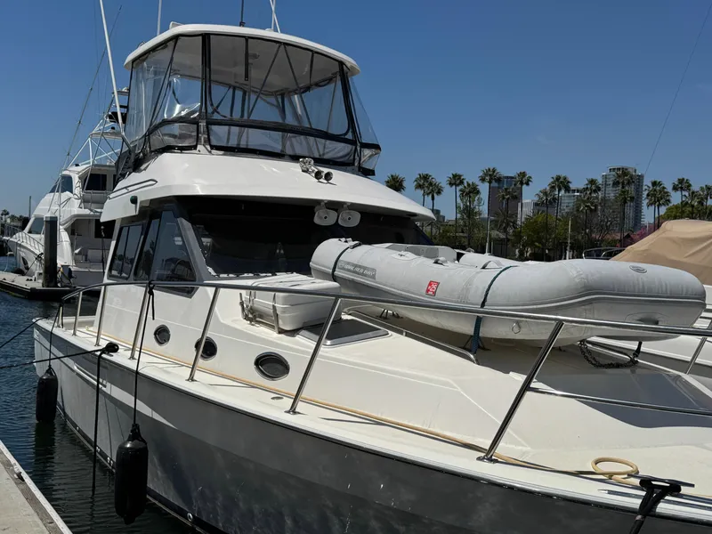 2003 Mediterranean 38 Convertible yacht docked with inflatable boat on deck.