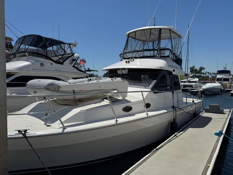 2003 Mediterranean 38 Convertible yacht docked at marina under clear blue sky.