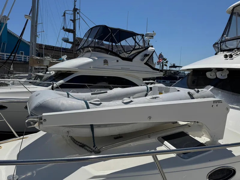 2003 Mediterranean 38 Convertible yacht with inflatable dinghy on deck, docked at marina.