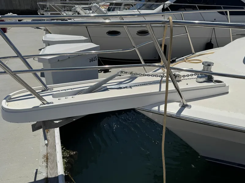 2003 Mediterranean 38 Convertible yacht docked with visible bow and railing.