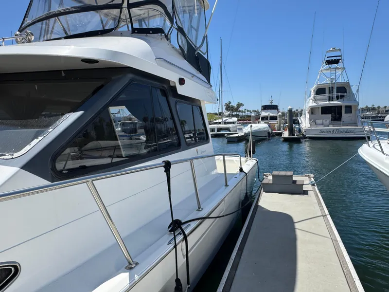 2003 Mediterranean 38 Convertible yacht docked at marina under clear blue sky.