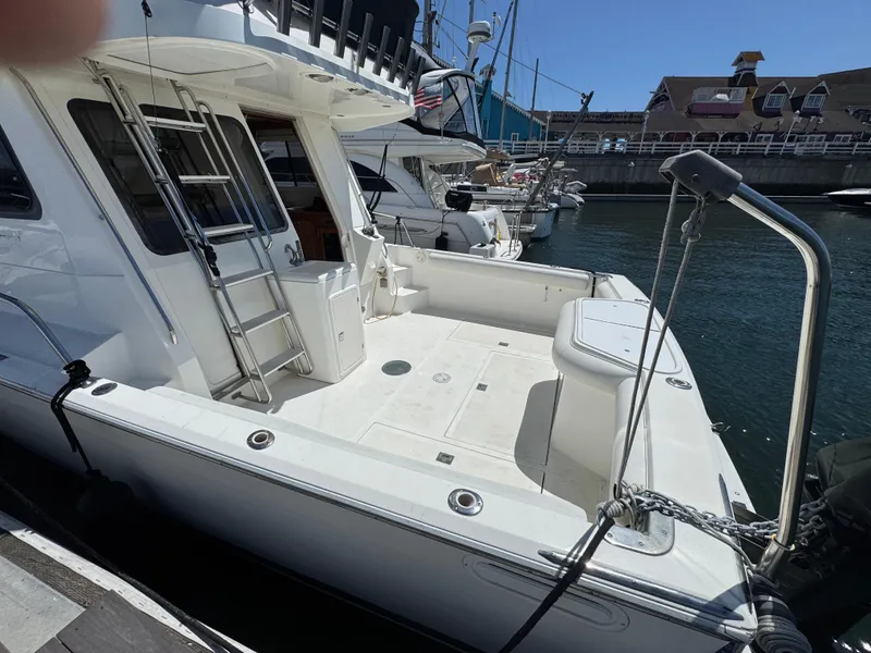 2003 Mediterranean 38 Convertible yacht docked at marina, featuring spacious deck and sleek design.