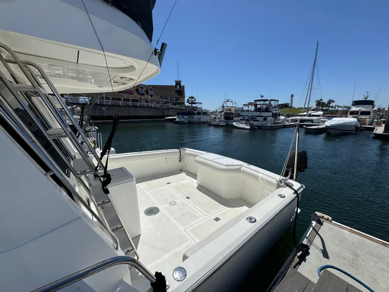 2003 Mediterranean 38 Convertible yacht docked at a marina under clear blue skies.