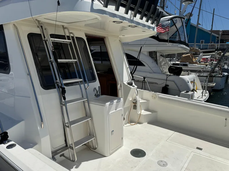 2003 Mediterranean 38 Convertible yacht with ladder and deck, docked at marina.