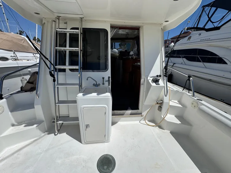 2003 Mediterranean 38 Convertible yacht deck with ladder and sink, docked at marina.