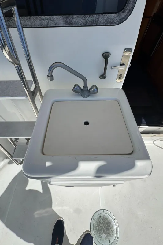 Boat sink on 2003 Mediterranean 38 Convertible yacht, featuring stainless steel fixtures.