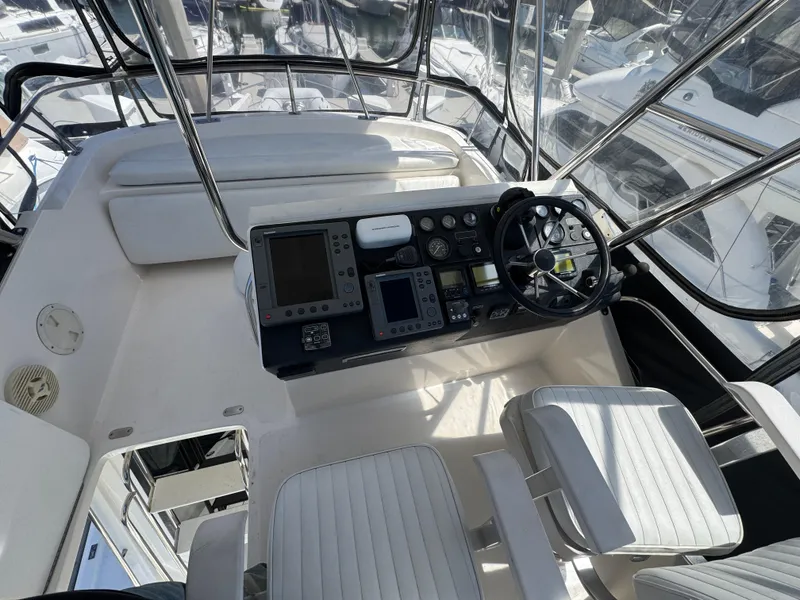 Cockpit of 2003 Mediterranean 38 Convertible yacht with steering wheel and navigation controls.