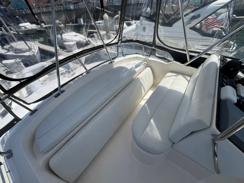 2003 Mediterranean 38 Convertible boat interior with white seating and marina view.