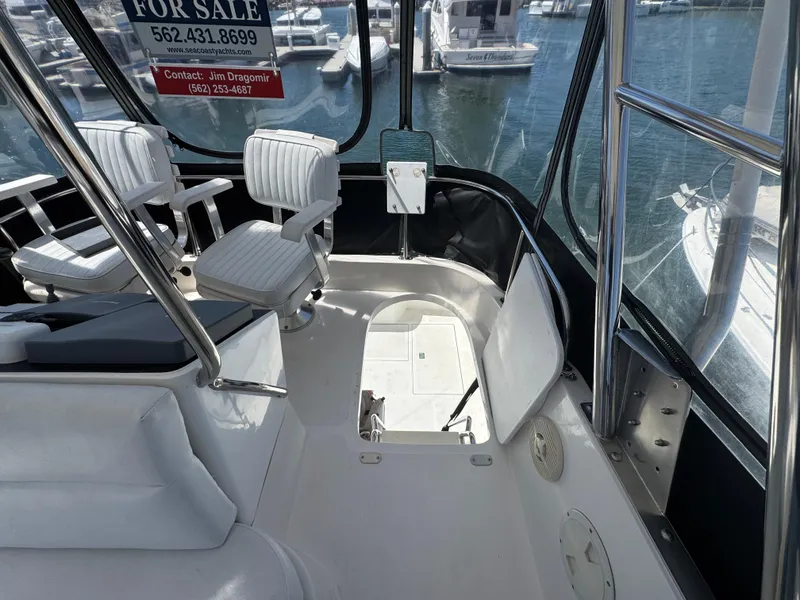 2003 Mediterranean 38 Convertible yacht interior with white seating, for sale sign visible.