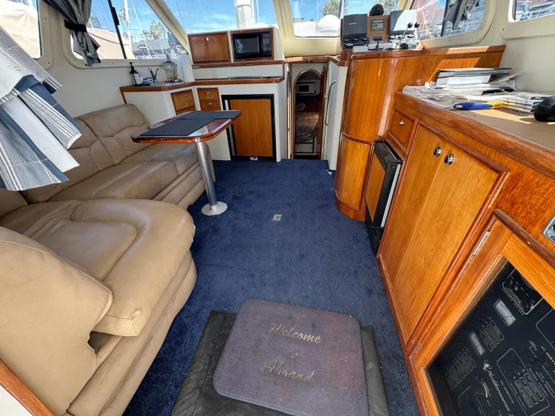 Interior of 2003 Mediterranean 38 Convertible yacht with plush seating and wooden cabinetry.