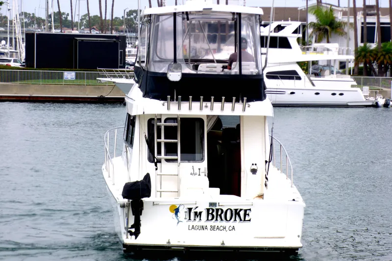 2003 Mediterranean 38 Convertible boat named "I'm Broke" in a marina.