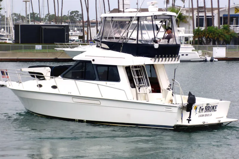 2003 Mediterranean 38 Convertible yacht named "I'm Broke" in a marina setting.