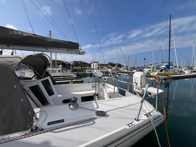Catalina 320 sailboat docked in marina, clear sky, calm water, 2005 model.