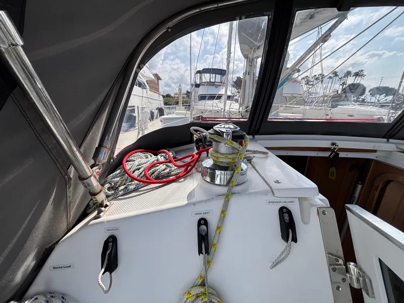 Cockpit view of a 2005 Catalina 320 sailboat with ropes and winch.