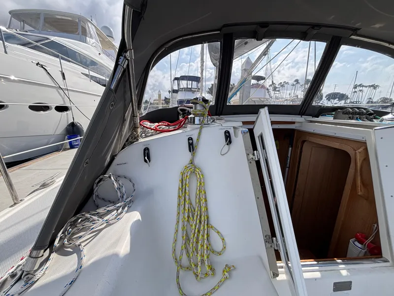 2005 Catalina 320 sailboat cockpit with ropes and open hatch at marina.