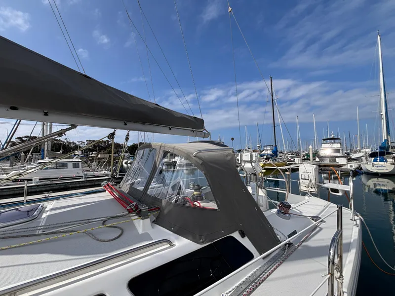 Catalina 320 sailboat, 2005 model, docked in a marina under a clear blue sky.