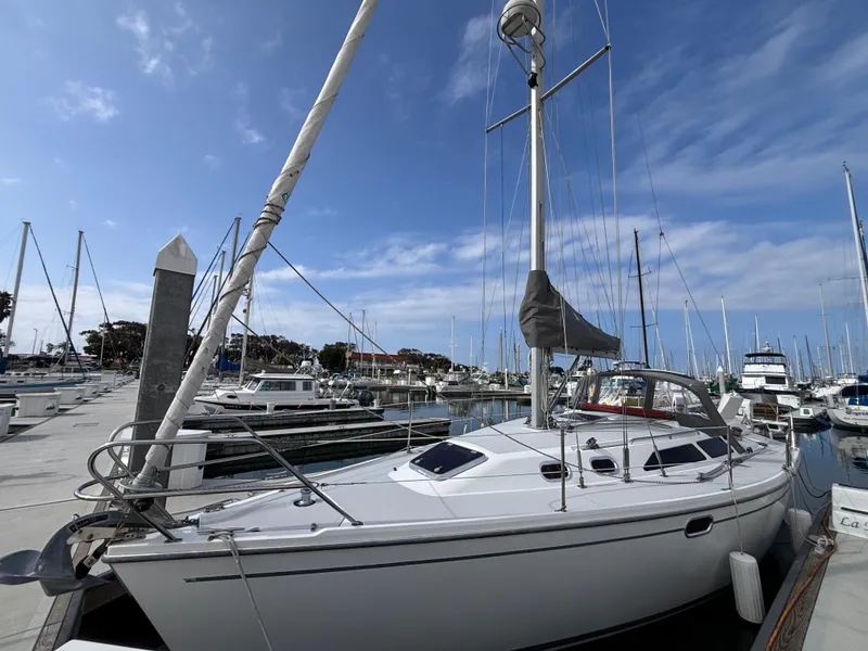 2005 Catalina 320 sailboat docked at marina under clear blue sky.