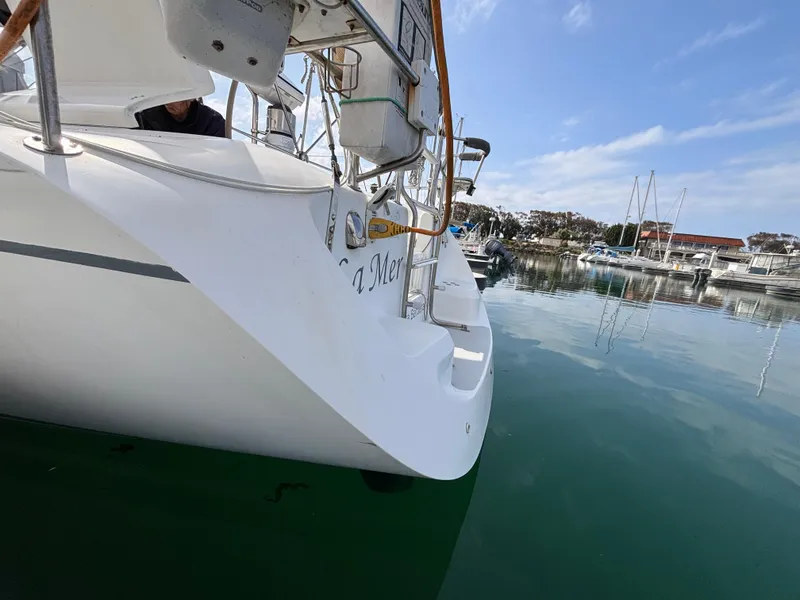 Catalina 320 sailboat from 2005 docked in a marina, reflecting on calm water.