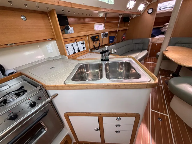 Interior of a 2005 Catalina 320 sailboat with kitchen and seating area.