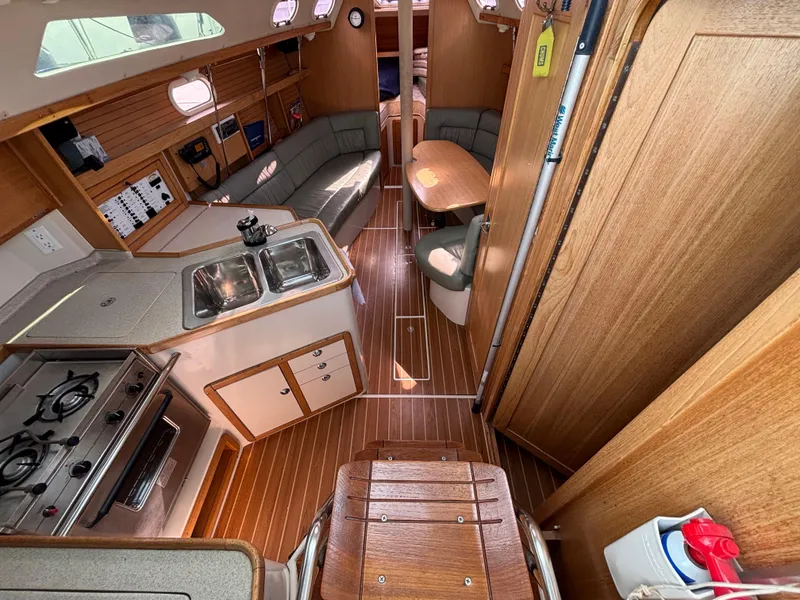 Interior of 2005 Catalina 320 sailboat with kitchen, seating, and wooden finishes.