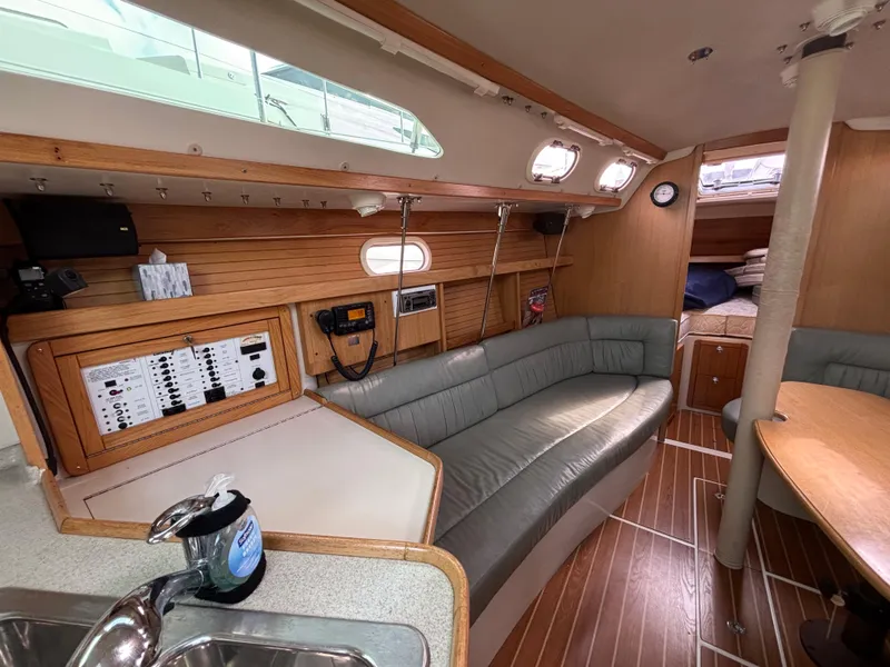 Interior of a 2005 Catalina 320 sailboat with wood paneling and seating area.