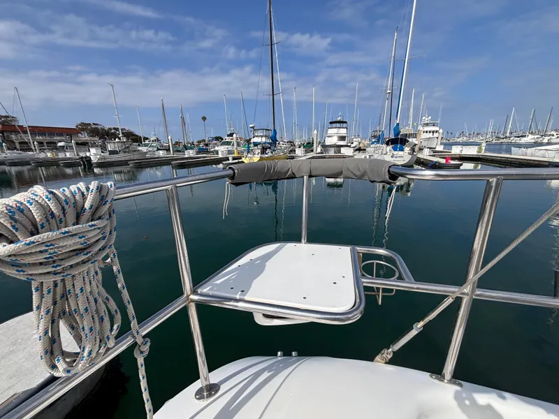 Catalina 320 sailboat in marina, 2005 model, with clear sky and calm water.