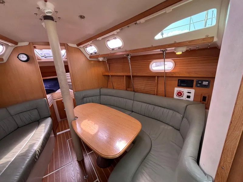 Interior of 2005 Catalina 320 sailboat with cozy seating and wooden table.