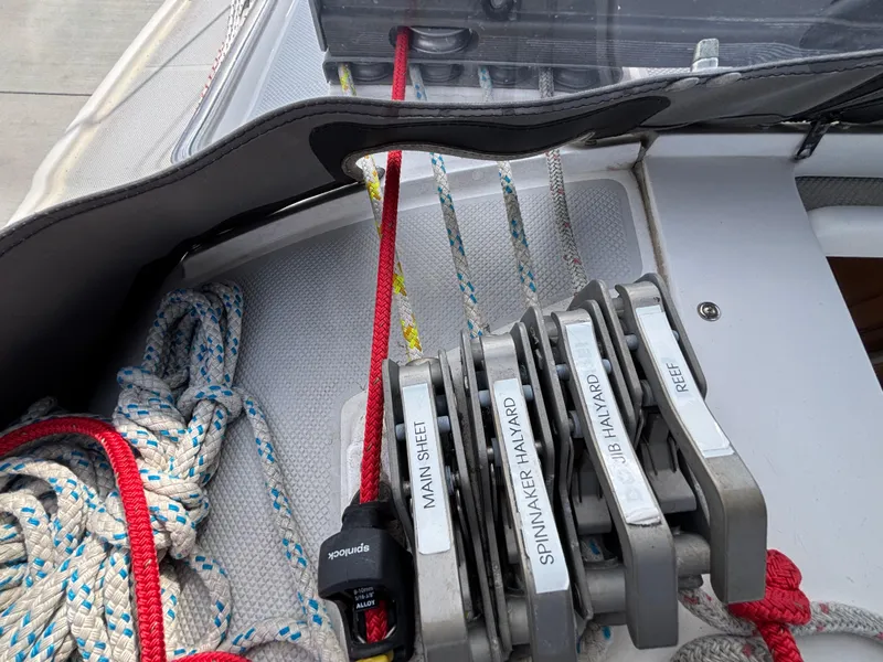 Sailing rigging on a 2005 Catalina 320, featuring labeled rope clutches and colorful lines.