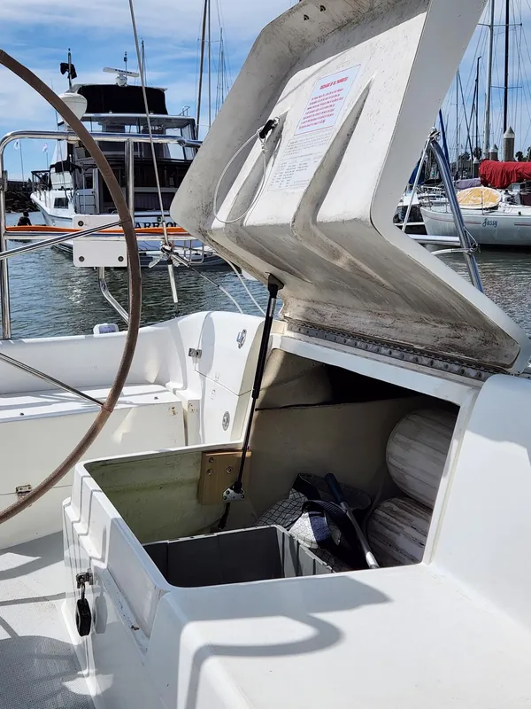 Open storage compartment on a 2005 Catalina 320 sailboat, docked in a marina.