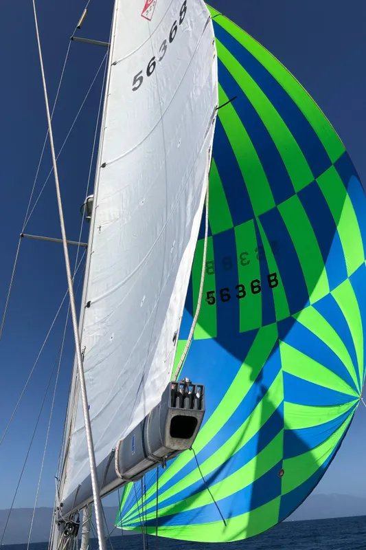 Sailing yacht Catalina 320 (2005) with vibrant blue and green spinnaker sail.