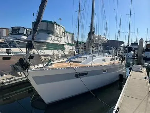 1987 Norseman 400 sailboat docked in marina under clear blue sky.