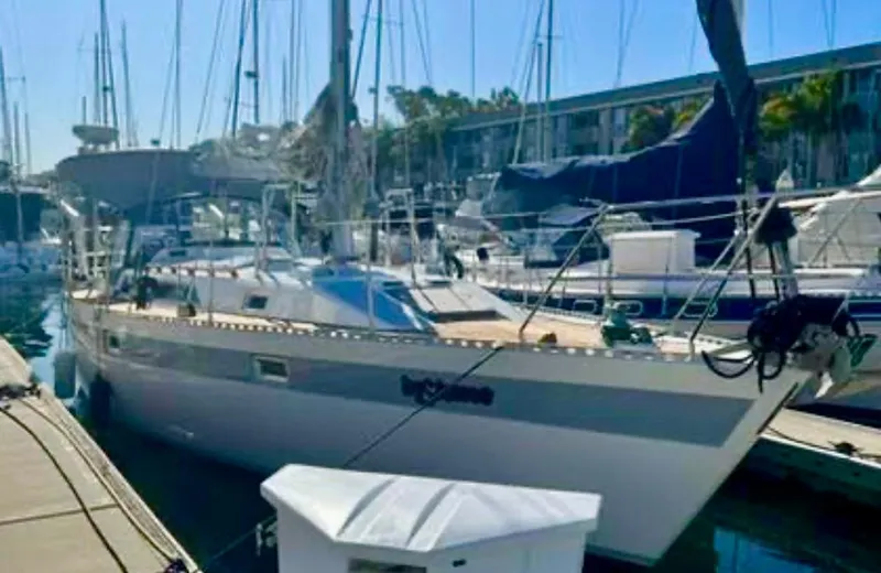 1987 Norseman 400 sailboat docked in a marina, surrounded by other boats.