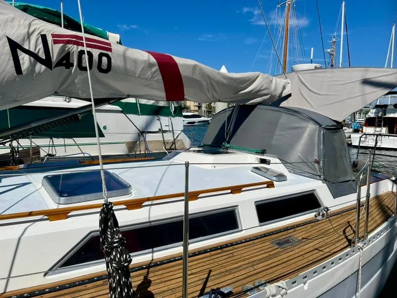 Sailboat Norseman 400, 1987 model, docked with clear blue sky background.