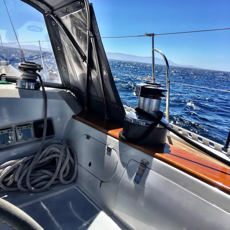 Cockpit view of 1987 Norseman 400 sailboat on open sea under clear blue sky.