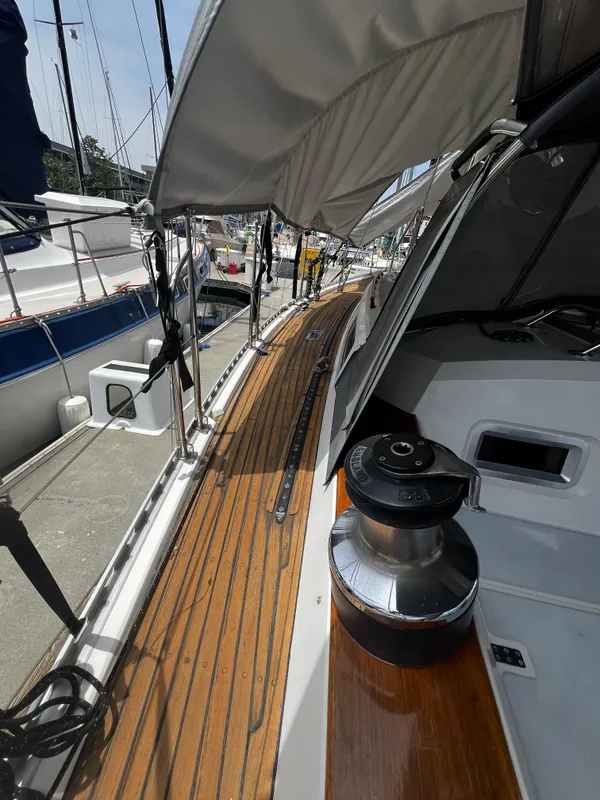 1987 Norseman 400 sailboat deck with wooden finish and winch, docked at marina.
