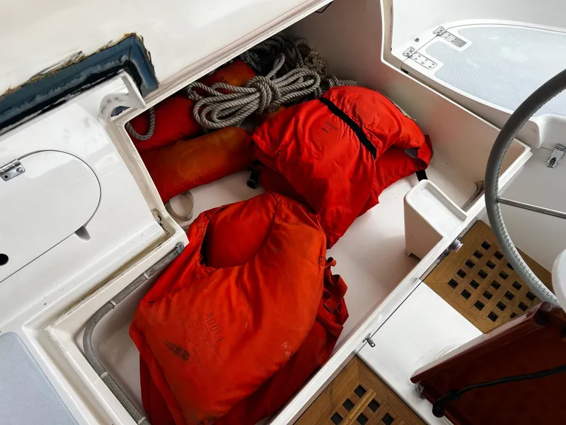 Storage compartment on 1987 Norseman 400 sailboat with life jackets and rope.
