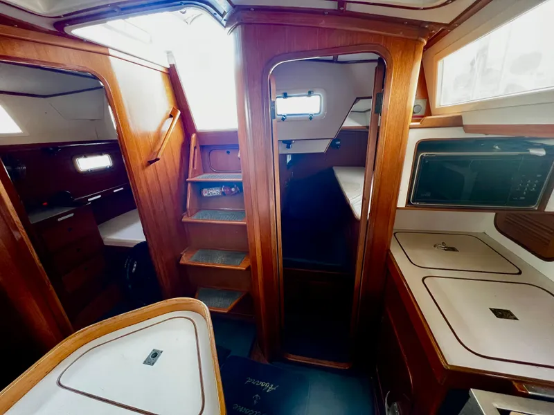 Interior of 1987 Norseman 400 sailboat with wooden cabinetry and compact layout.