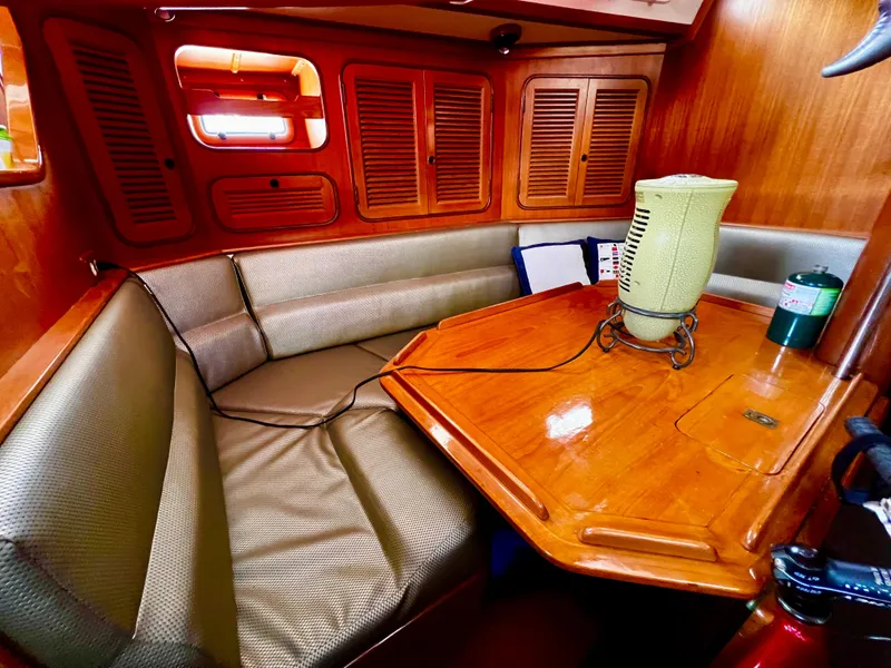 Cozy 1987 Norseman 400 yacht interior with wooden table and cushioned seating.