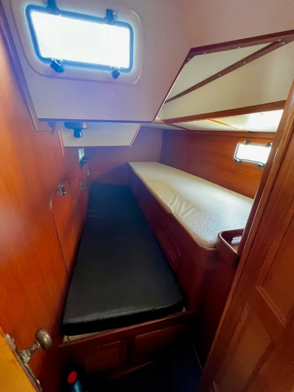 Cozy cabin interior of 1987 Norseman 400 sailboat with wooden paneling and twin berths.
