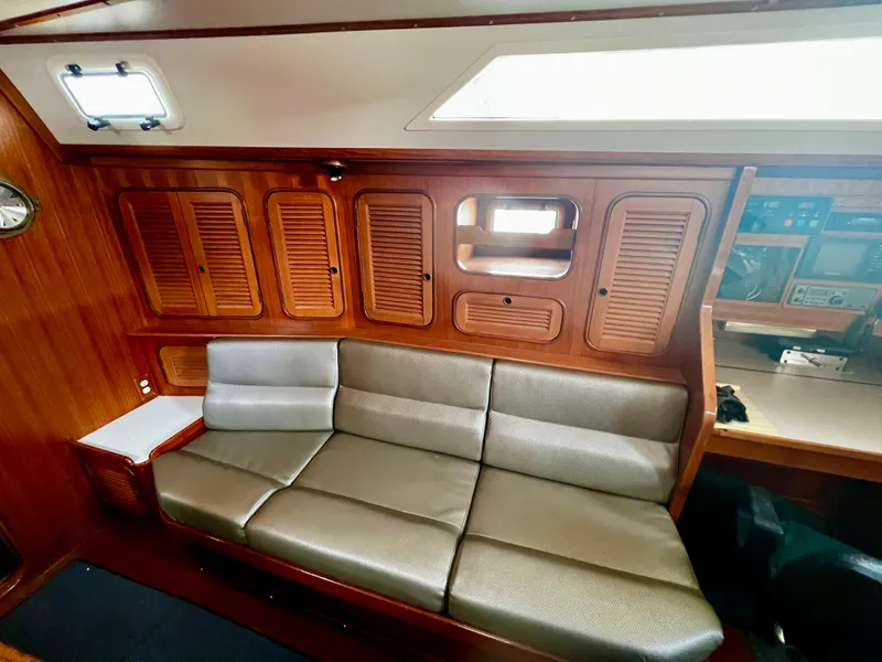 1987 Norseman 400 yacht interior with wooden cabinets and a comfortable gray sofa.